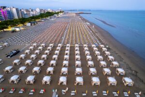 Aerial shot of organized beach cabanas in Lignano Sabbiadoro, Italy at evening.
