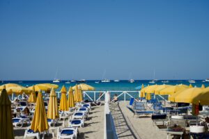 Beach umbrellas line the sunny shore.
