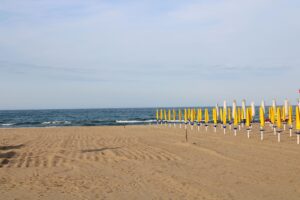 A serene summer beach scene with yellow umbrellas in Abruzzo, Italy.